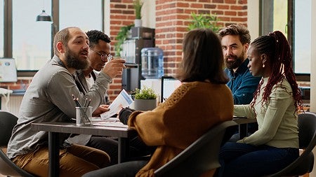 image of a group of people in a discussion sitting at a table