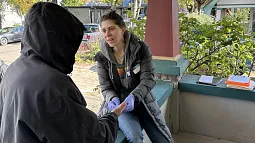 two individuals sitting on a wall talking